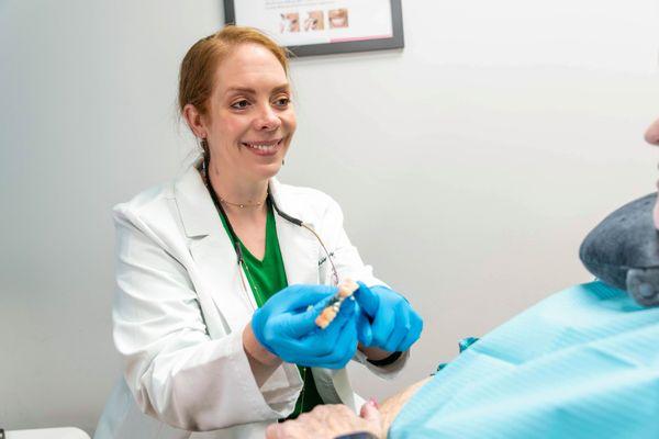 Dr. Hills showing patient model teeth at Harwood Smiles