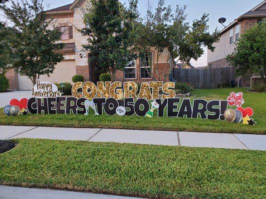 Couple celebrating 50th years strong with a yard sign.