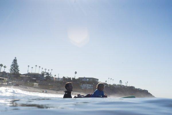 Perfect conditions for surf lessons in front of our shop at Moonlight Beach.