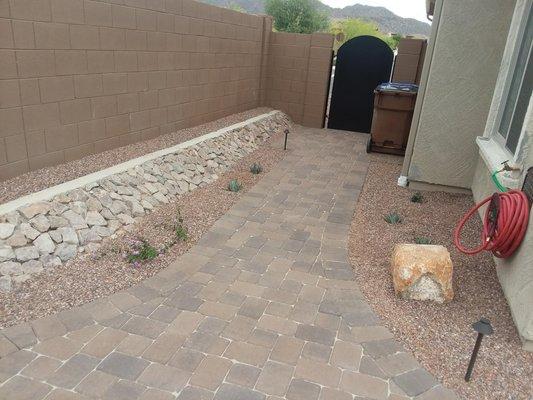 Walkway from front to rear house with paver sidewalk.