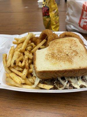 Cheesesteak sand-which with half fries half onion rings.