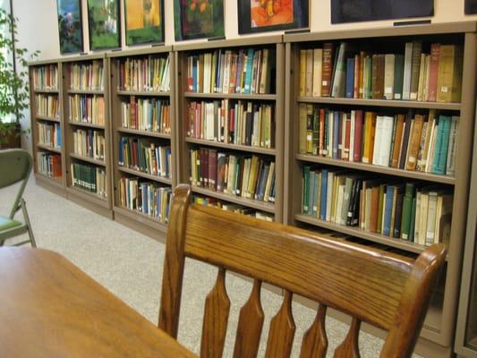 a table, chair, and shelves in the resource library