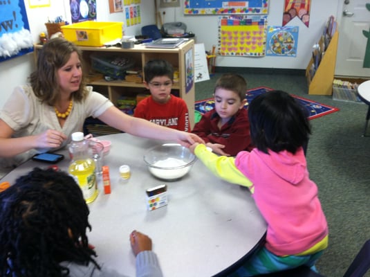 Ms. Marissa working with pre-k students to measure and mix!