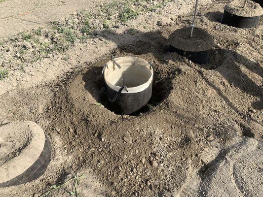 The fabric bag with the temporary cylinder is placed in the hole for planting.