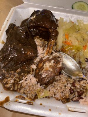 Jerk chicken, rice and peas, and cabbage .