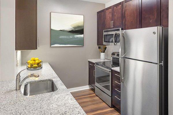 Contemporary kitchens with granite countertops, under cabinet lighting and GE® stainless steel appliances