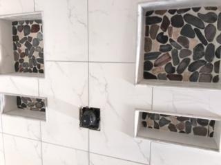 Shower was gutted and we expanded the shower then tiled the walls, added recessed soap dishes, and did the pebble custom show...