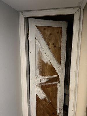 Unfinished bathroom door with nails sticking out, not sanded, handle hole not drilled, not sanded before painting raw wood.