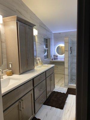 Quartz Countertops with All wood cabinets brushed nickel pulls. Matching medicine cabinet with power outlets on the left and right.