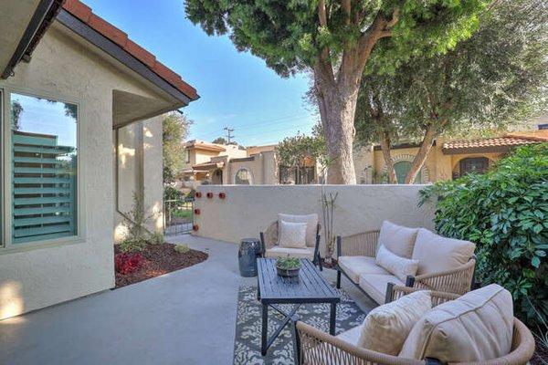 Inviting patio with cushioned seating, lush greenery, and a serene atmosphere.