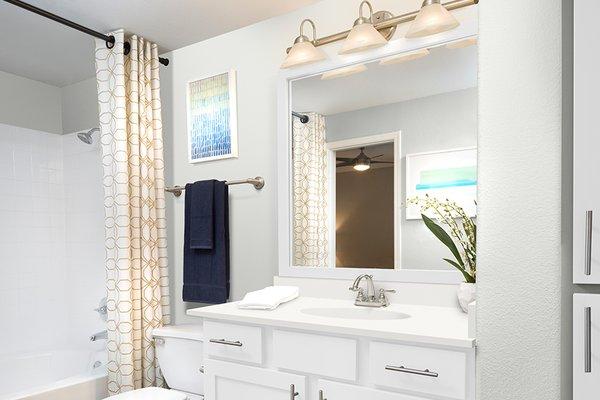 Upgraded bathrooms feature painted, shaker-style cabinets and framed mirrors