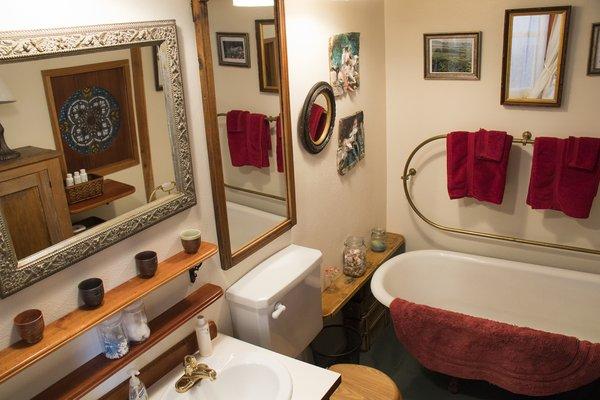 The Bungalow enchanting bathroom with claw foot tub. Spa products are shown.