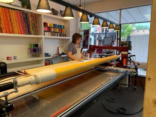 Shop owner Randi Deem doing long arm quilting for a customer.