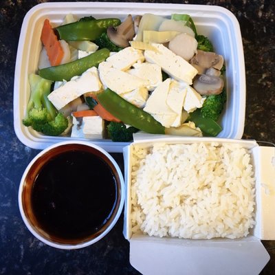 Mixed vegetables, tofu and steamed rice with a brown sauce.