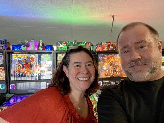 Patrons in front of several pinball machines.