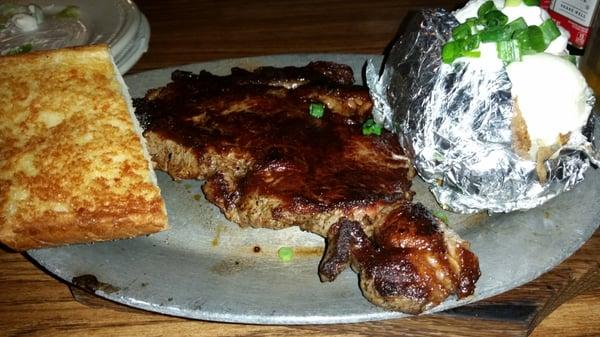 Ribeye steak with baked potato and bread