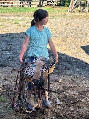 Lilly learning to saddle her horse, Scotte.