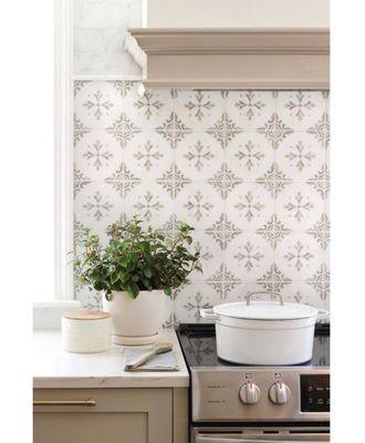 This kitchen backsplash combines soft, neutral colors with a bold decorative tile to create a subtly unique focal point in the kitchen.