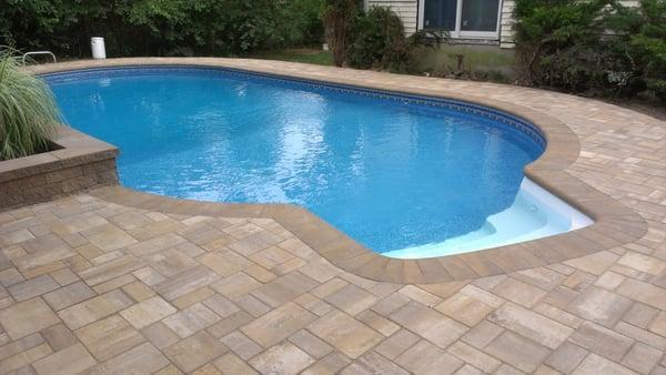 Residential pool deck in pavers w/ concrete sub-base.