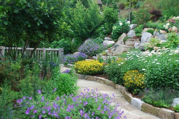 Residential landscape design by Snow Creek Landscaping featuring a stone walkway and perennials