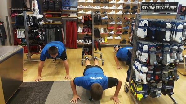 Staff doing 5 push-ups for donating $5 to a good cause