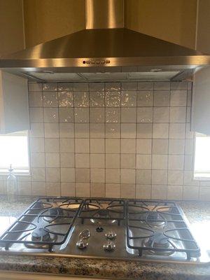 Horrible installation of backsplash, specifically under vent, around windows