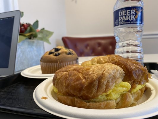 Sausage egg and cheese on a croissant & warmed blueberry muffin