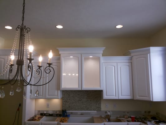 Installed can lights in kitchen cabinets.