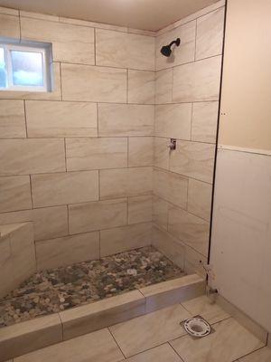 Shower , River Rock on the shower pan, curb, tile floor with bullnose