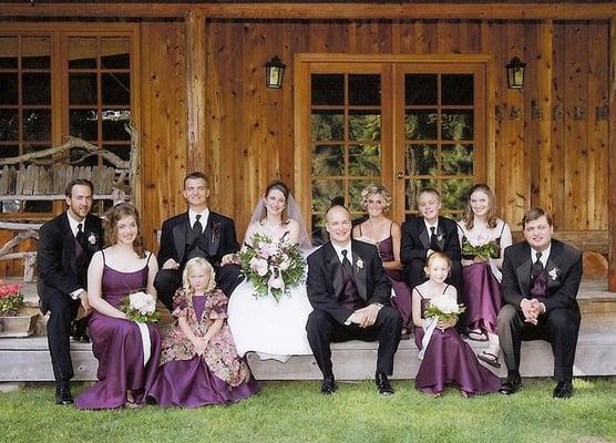 A Wellspring wedding party poses on the porch of the Tatoosh Lodge