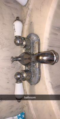 bathroom faucet. i was told it was going to be replaced. this is after i tried cleaning it. it was worse