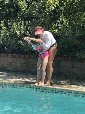 Samantha teaching her to dive in the pool.