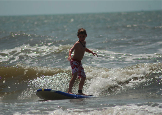 Tyler surfing a thigh high wave.