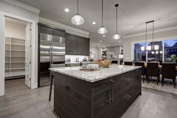 The modern gray open-plan kitchen features dark gray cabinets and granite countertops