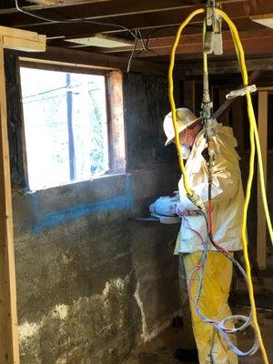 Tex preparing to enlarge this basement window by cutting concrete out of the bottom edge.