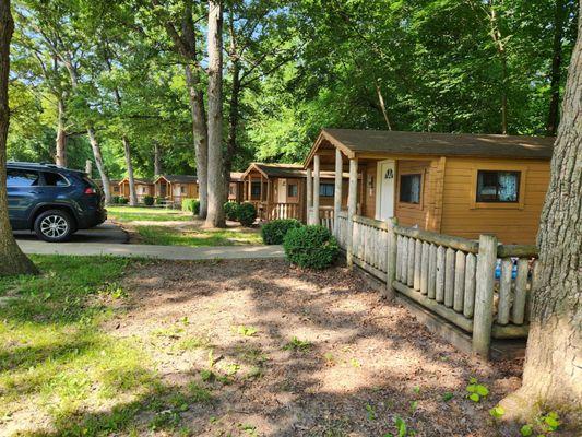 Rustic two room cabins. Cabin 26 is closest to the camera with an extended deck.