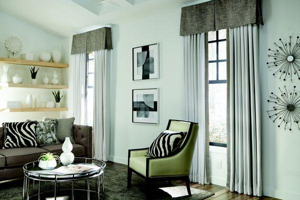 Classic neutral banded drapes with animal print pillows add a touch of fun to this living space.