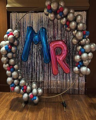 Organic garland with large balloon letters attached to a ring structure.