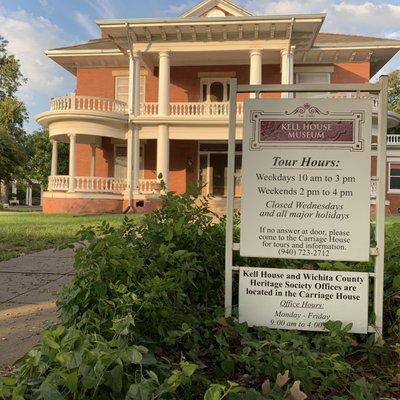 Front view of the Kell House Museum in the morning with hours of operations.