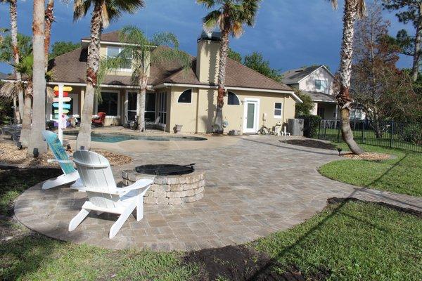 Extended pool deck area with pavers and a fire pit.