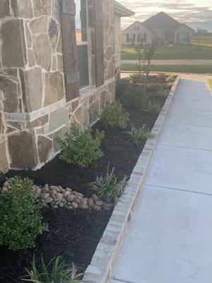 Bordered flower bed and trees.