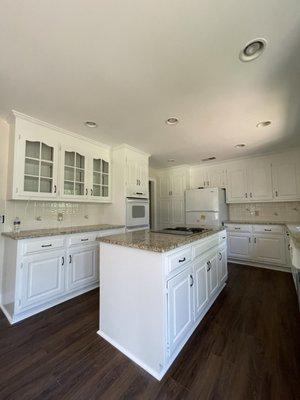 Final product of kitchen cabinets we painted along with new flooring in the kitchen area