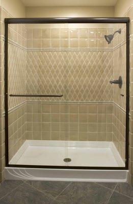 DELUXE SEMI-FRAMELESS SHOWER ENCLOSURE WITH OIL RUBBED BRONZE (POWDER COAT) ALUMINUM TRIM.