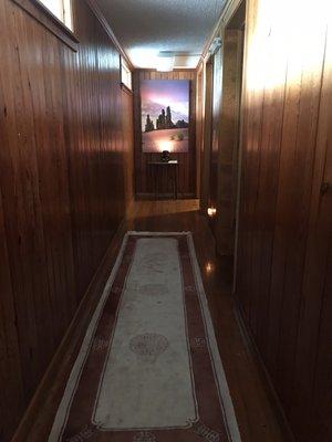 Hallway leading to 3 individual treatment rooms and the bathroom.