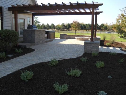 Patio with pergola, outdoor kitchen and fire pit.