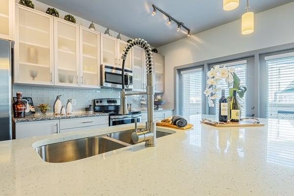 Gourmet kitchens with quartz islands, granite counters, glass tile back splashes, glass cabinetry and built-in USB charging stations.