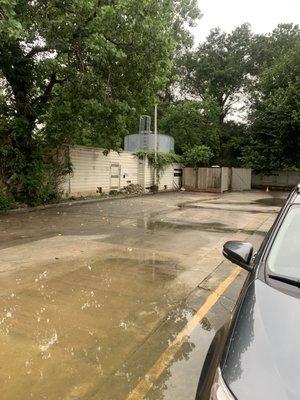 Water pooling in parking lot and broken down fence