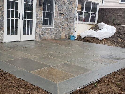 Flagstone patio with stone veneer wall