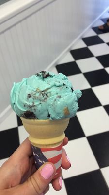 One Scoop of the Cookie Monster on a sugar cone.