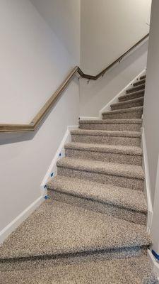 Staircase trim: holes, unfinished edges and handrail stain on carpet.